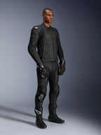 Modello che indossa la giacca in pelle Alpinestars Dusk in Black Laser, abbinata a pantaloni racing in pelle nera coordinati, guanti GP Pro e stivali tecnici da pista. Equipaggiamento completo da moto con protezione esterna DFS sulle spalle e vestibilità atletica per guida sportiva e stradale.