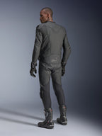 Pilota uomo visto da dietro che indossa la giacca in pelle Alpinestars Dusk Airflow in Black Black, abbinata a pantaloni, guanti e stivali in pelle coordinati, mettendo in risalto le ampie perforazioni sulla schiena e la vestibilità sportiva.