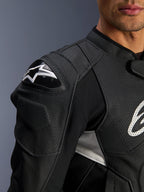 Alpinestars Dusk Airflow Leather Jacket, nero e bianco, vista ravvicinata di spalla e torace, con pelle traforata per la ventilazione, protezione per le spalle DFS con logo Alpinestars bianco, design sportivo.