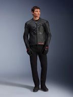 Giacca in pelle Alpinestars GP Plus R V4 Airflow, nero, indossata da un modello con guanti e pantaloni neri coordinati, caratterizzata da pannelli in pelle traforata, grande logo a stella in tono sul petto e vestibilità sportiva.