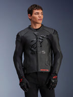 Alpinestars GP Plus R V4 Airflow Leather Jacket, giacca da moto racing in pelle nera con costruzione in pelle traforata, logo ASTARS sul petto e protezioni per le spalle DFS, indossata con guanti neri e rossi