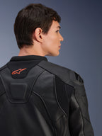 Giacca in pelle Alpinestars GP Plus R V4 Airflow, nera, vista posteriore ravvicinata su un modello, con pelle traforata di livello racing, pannelli tecnici elasticizzati e un piccolo logo Alpinestars arancione sul colletto, abbigliamento professionale da moto