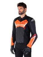 Giacca in pelle Alpinestars Faster V3, nero e rosso fluo, giacca da moto sportiva premium con accenti bianchi e rossi, marchio Alpinestars su petto e maniche, indossata con guanti e pantaloni da moto neri