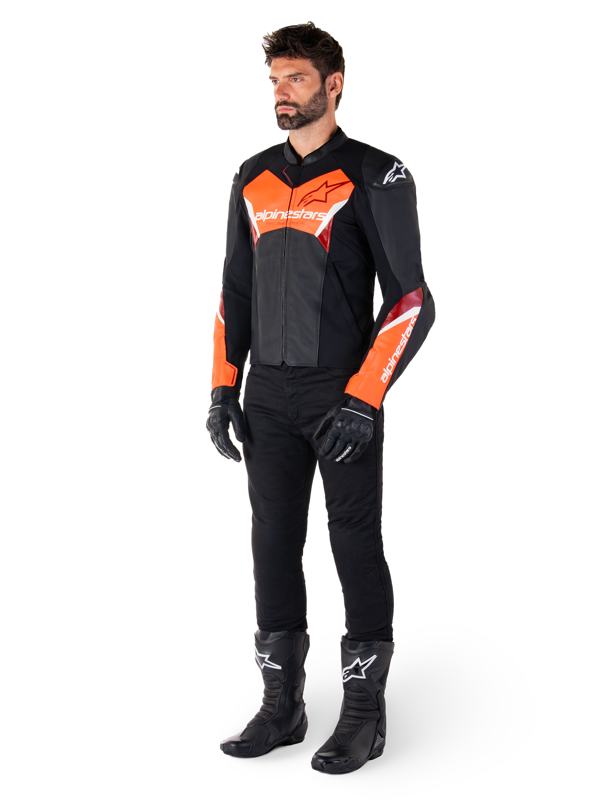 Motociclista che indossa la giacca in pelle Alpinestars Faster V3 in nero e rosso fluo, abbinata a pantaloni da moto, guanti e stivali neri. La giacca presenta una silhouette di derivazione racing con audaci accenti rosso fluorescente su petto e maniche, marchio Alpinestars bianco e una struttura in pelle premium.