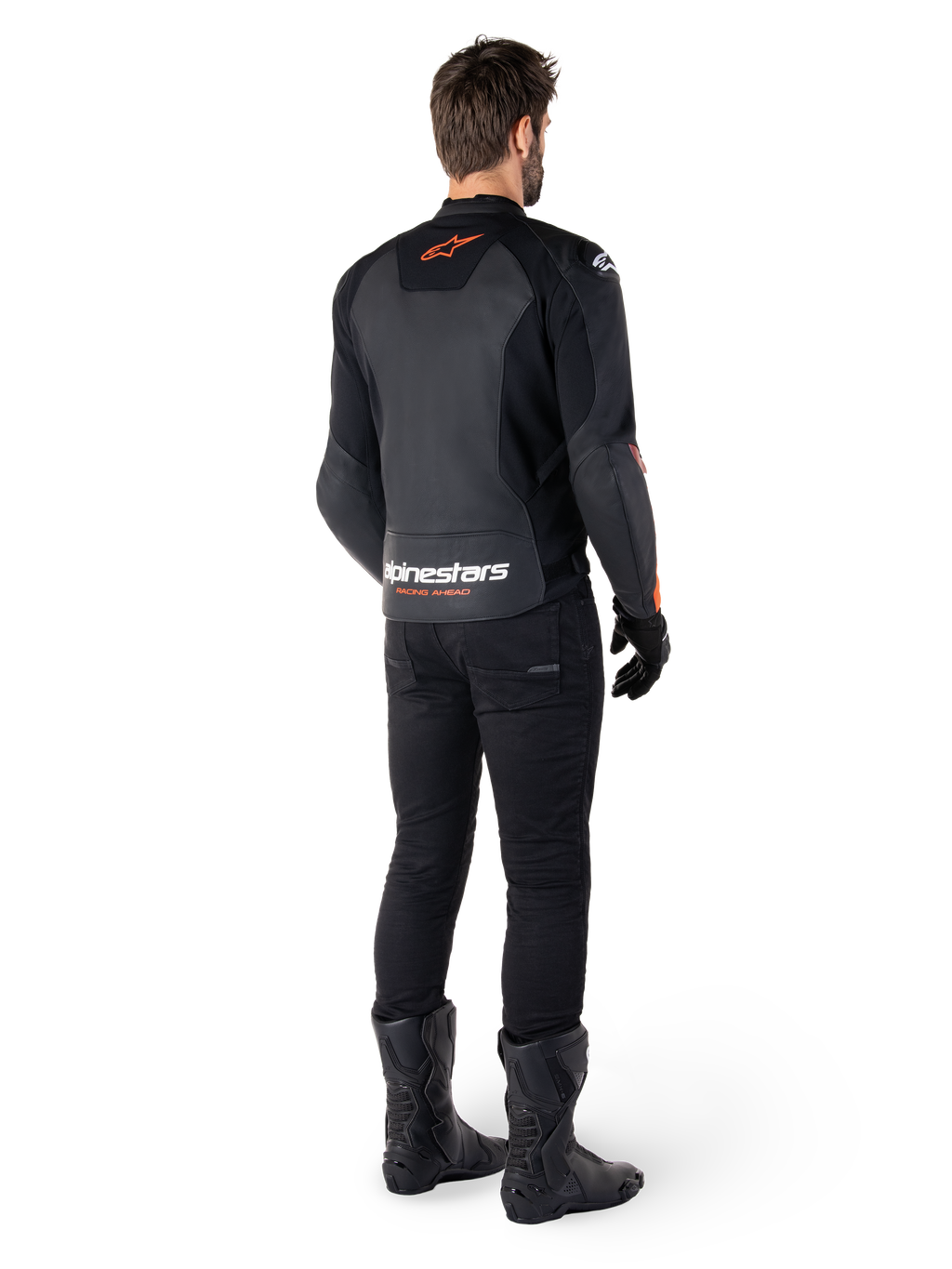 Giacca in pelle Alpinestars Faster V3, giacca da moto sportiva, nero e rosso fluo, vista posteriore indossata con pantaloni neri e stivali neri, con scritta 'alpinestars RACING AHEAD' sulla parte inferiore della schiena e un piccolo logo a stella rosso, struttura in pelle dal taglio sportivo