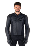Giacca in pelle Alpinestars Faster V3, giacca da moto nera, pelle premium con pannelli elasticizzati HRSF, vestibilità sportiva, spalle rinforzate con protezioni, indossata con guanti neri, equipaggiamento professionale per la guida su strada