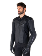 Giacca in pelle Alpinestars Faster V3, giacca da moto sportiva, Nero, indossata da un modello uomo con pantaloni e guanti neri, costruzione in pelle pregiata con pannelli elasticizzati e protezioni per le spalle DFS GP Lite, silhouette sportiva elegante e moderna