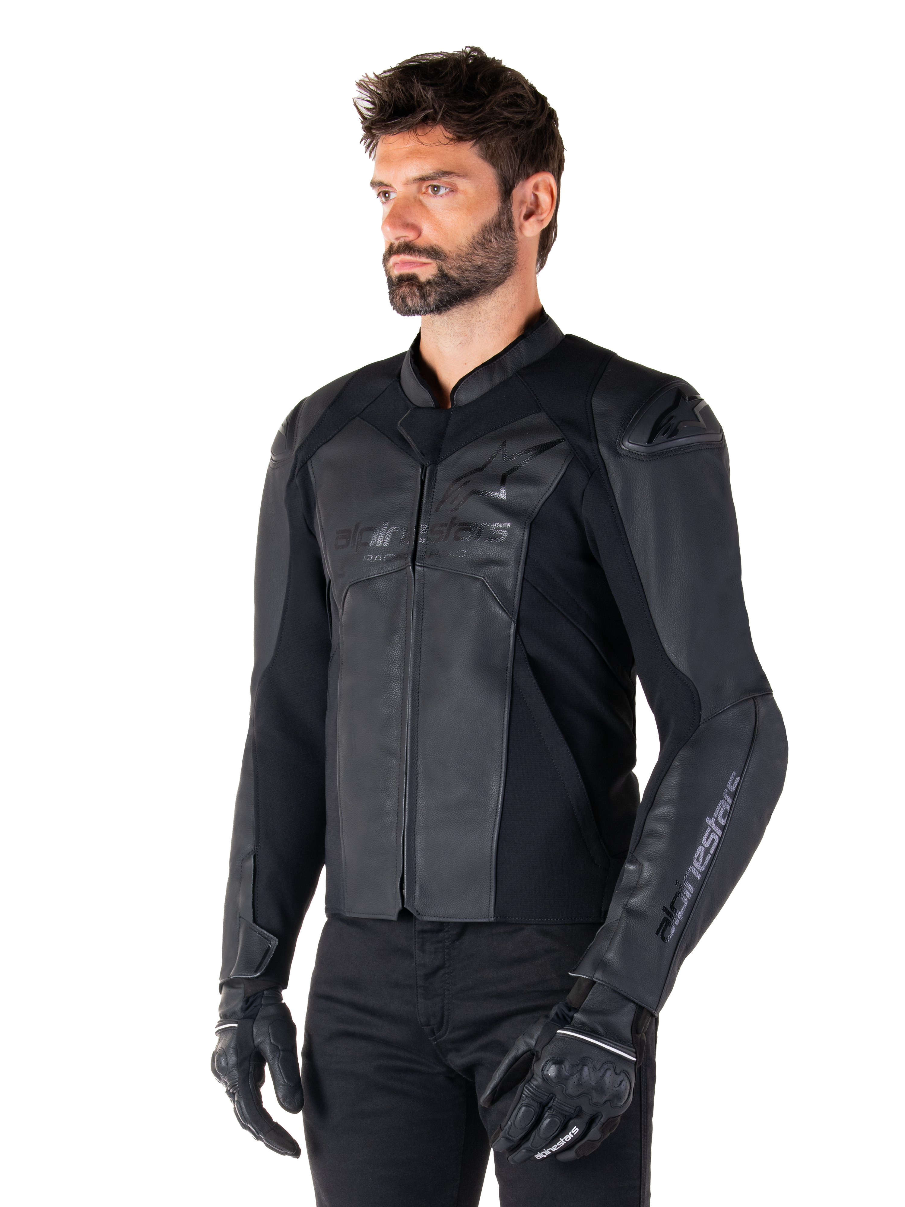 Giacca in pelle Alpinestars Faster V3, giacca da moto sportiva, Nero, indossata da un modello uomo con pantaloni e guanti neri, costruzione in pelle pregiata con pannelli elasticizzati e protezioni per le spalle DFS GP Lite, silhouette sportiva elegante e moderna