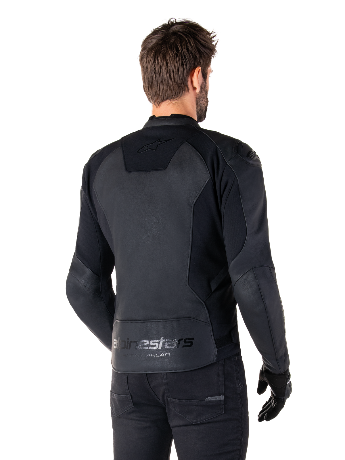 Alpinestars Faster V3 Leather Jacket, Nero, vista posteriore del modello che indossa la giacca sportiva da moto, con loghi 'alpinestars' e 'RACING AHEAD' sulla parte inferiore della schiena, pelle premium con pannelli opachi, silhouette sportiva moderna per la guida della moto