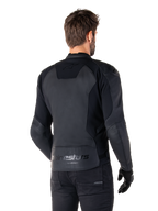 Alpinestars Faster V3 Leather Jacket, Nero, vista posteriore del modello che indossa la giacca sportiva da moto, con loghi 'alpinestars' e 'RACING AHEAD' sulla parte inferiore della schiena, pelle premium con pannelli opachi, silhouette sportiva moderna per la guida della moto
