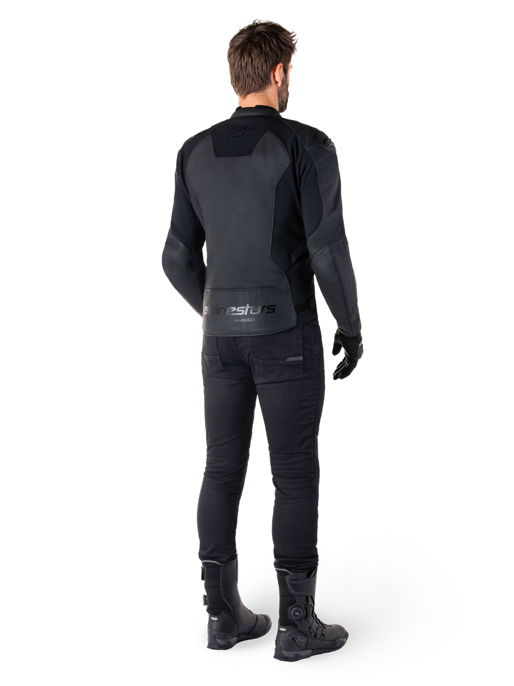 Alpinestars Faster V3 Leather Jacket, giacca in pelle da moto, nero, vista posteriore su un pilota, con pannelli in pelle pregiata e marchio Alpinestars in rilievo, abbinata a pantaloni e stivali da moto neri per un look sportivo completo.