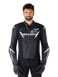 Giacca in pelle Alpinestars Faster V3, giacca da moto sportiva nera e bianca, con loghi bianchi e scritta 'Racing Ahead' sul petto, design elegante in pelle con dettagli angolari sulle maniche, indossata con guanti da corsa neri