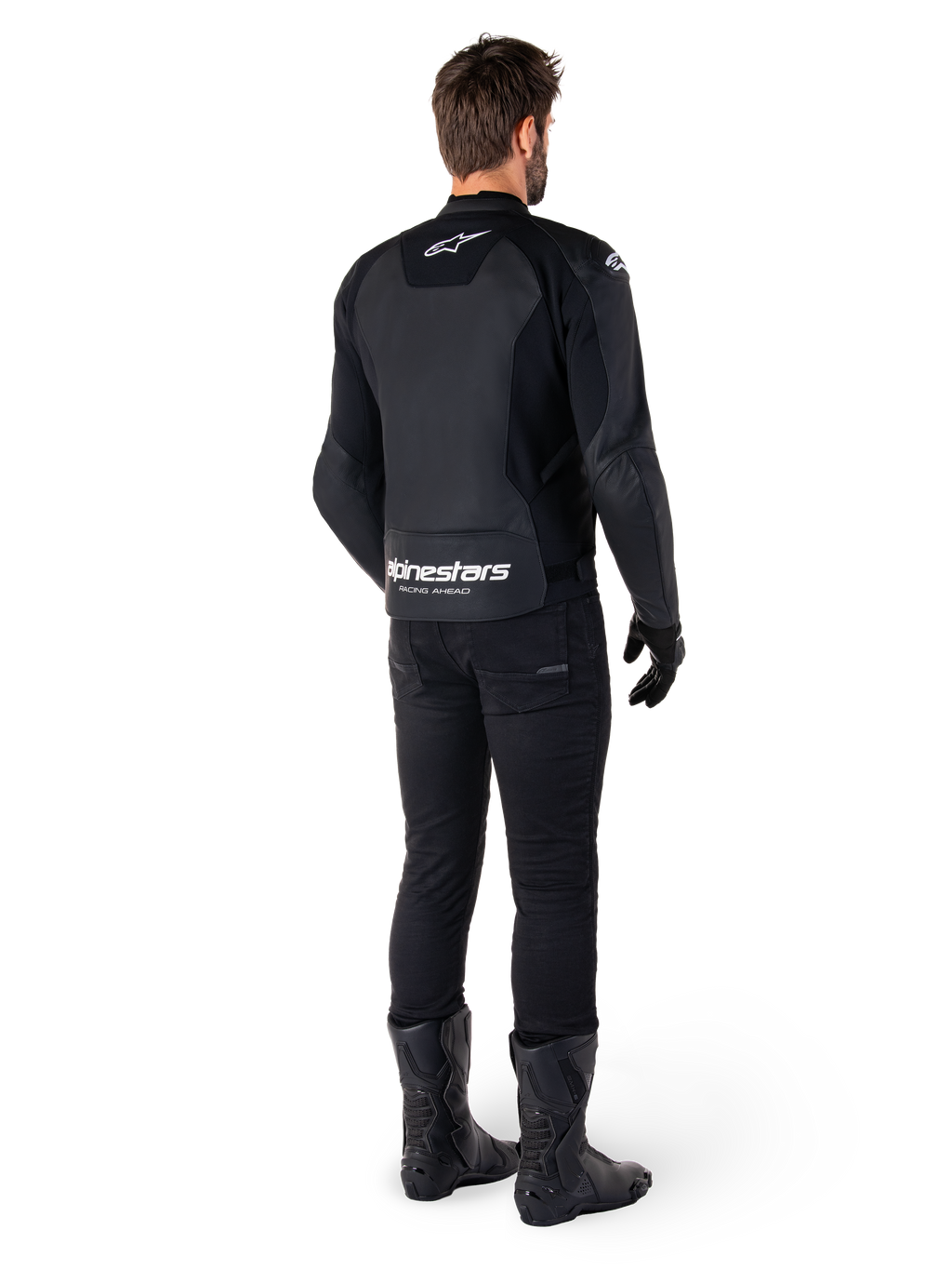 Giacca in pelle Alpinestars Faster V3, vista posteriore, nero e bianco, con marchio 'alpinestars RACING AHEAD' sulla parte bassa della schiena, indossata con pantaloni e stivali da moto neri, giacca da moto in pelle di derivazione sportiva con pannelli elasticizzati