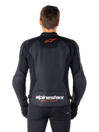 Giacca in pelle Alpinestars Faster V3 Airflow, nero, vista posteriore con pannelli in pelle traforata per la ventilazione, logo a stella Alpinestars rosso e marchio bianco sulla parte inferiore della schiena, indossata con pantaloni e guanti neri.