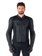 Uomo che indossa la giacca in pelle Alpinestars Faster V3 Airflow, giacca da moto nera con pannelli in pelle traforata, logo Alpinestars sul petto, abbinata a guanti da moto neri, scatto frontale in studio