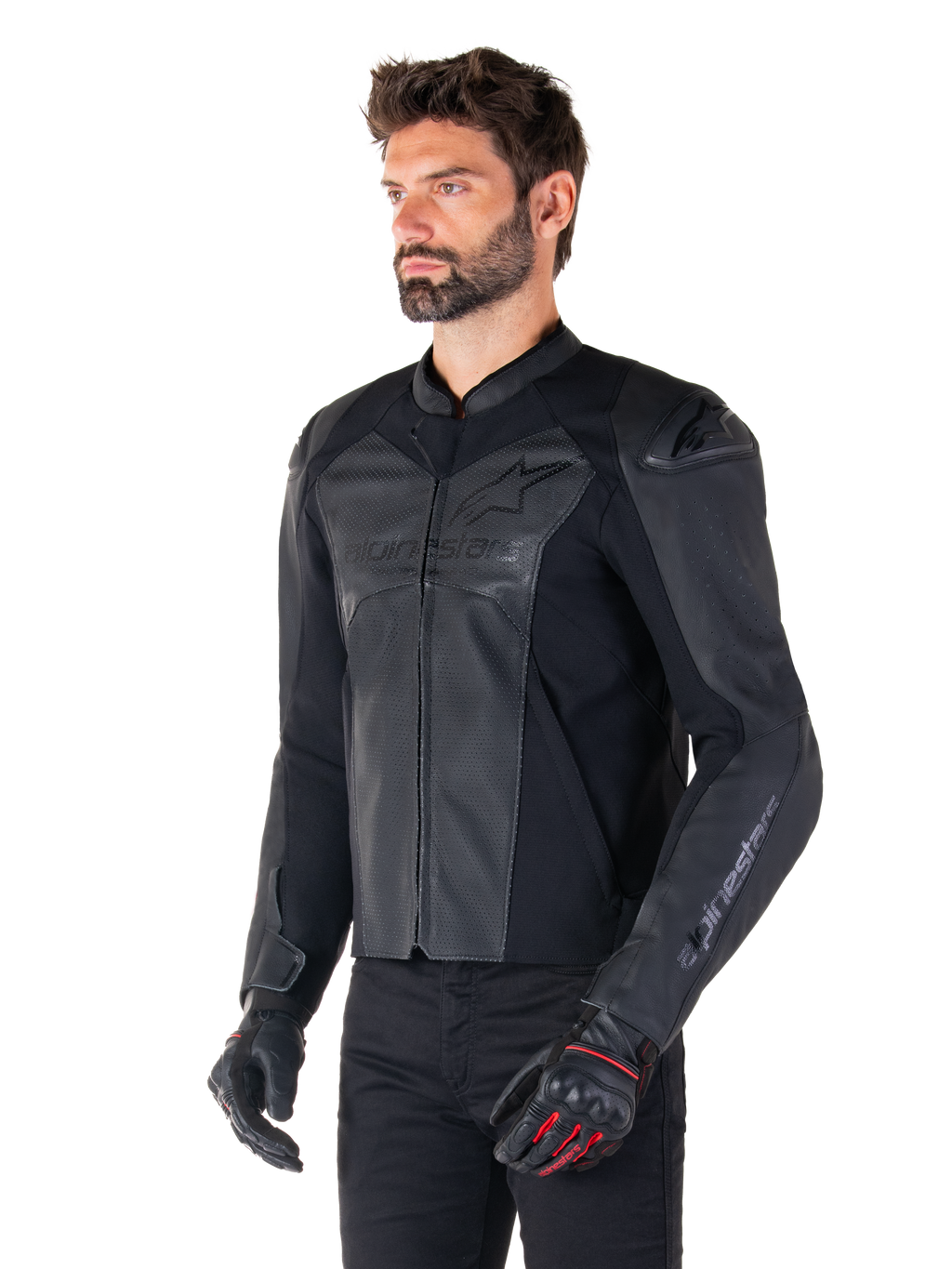 Modello che indossa la giacca in pelle Alpinestars Faster V3 Airflow in Black Black, giacca da moto sportiva con pelle traforata e pannelli elasticizzati, abbinata a pantaloni neri e guanti neri con accenti rossi, stile raffinato di derivazione racing