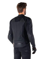 Giacca in pelle Alpinestars Faster V3 Airflow, nero, vista posteriore di un uomo che indossa una giacca da moto sportiva in pelle, con pannelli posteriori traforati, inserti elasticizzati e logo Alpinestars sul bordo inferiore, abbinata a pantaloni e guanti neri