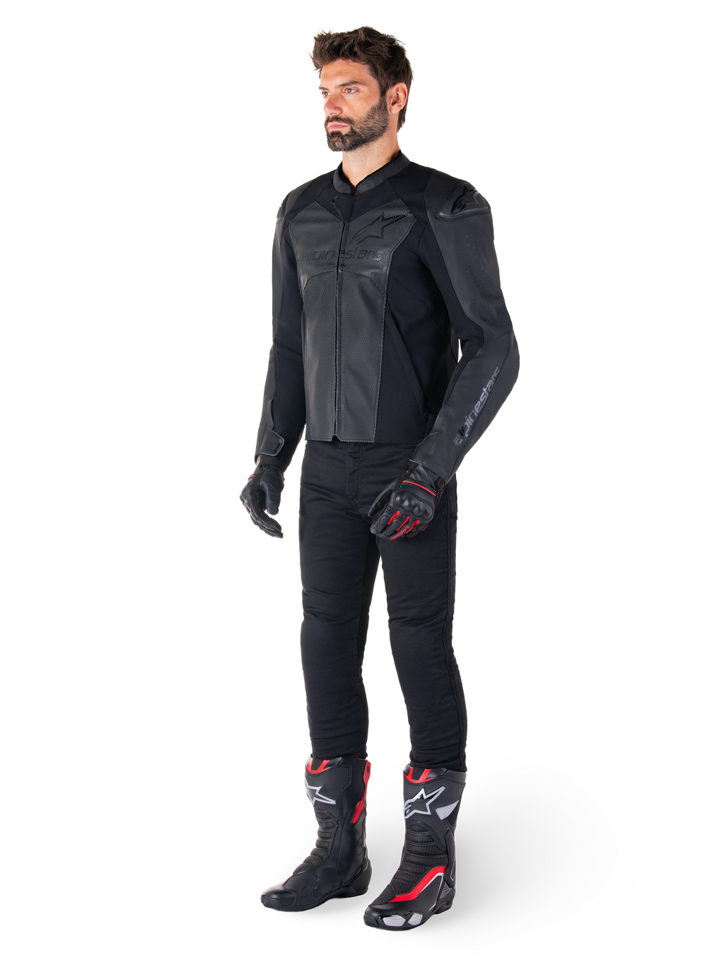 Uomo che indossa la giacca in pelle Alpinestars Faster V3 Airflow in Nero Nero, abbinata a pantaloni neri, guanti da moto neri e rossi e stivali da corsa neri con dettagli rossi e bianchi, equipaggiamento da guida sportiva completo