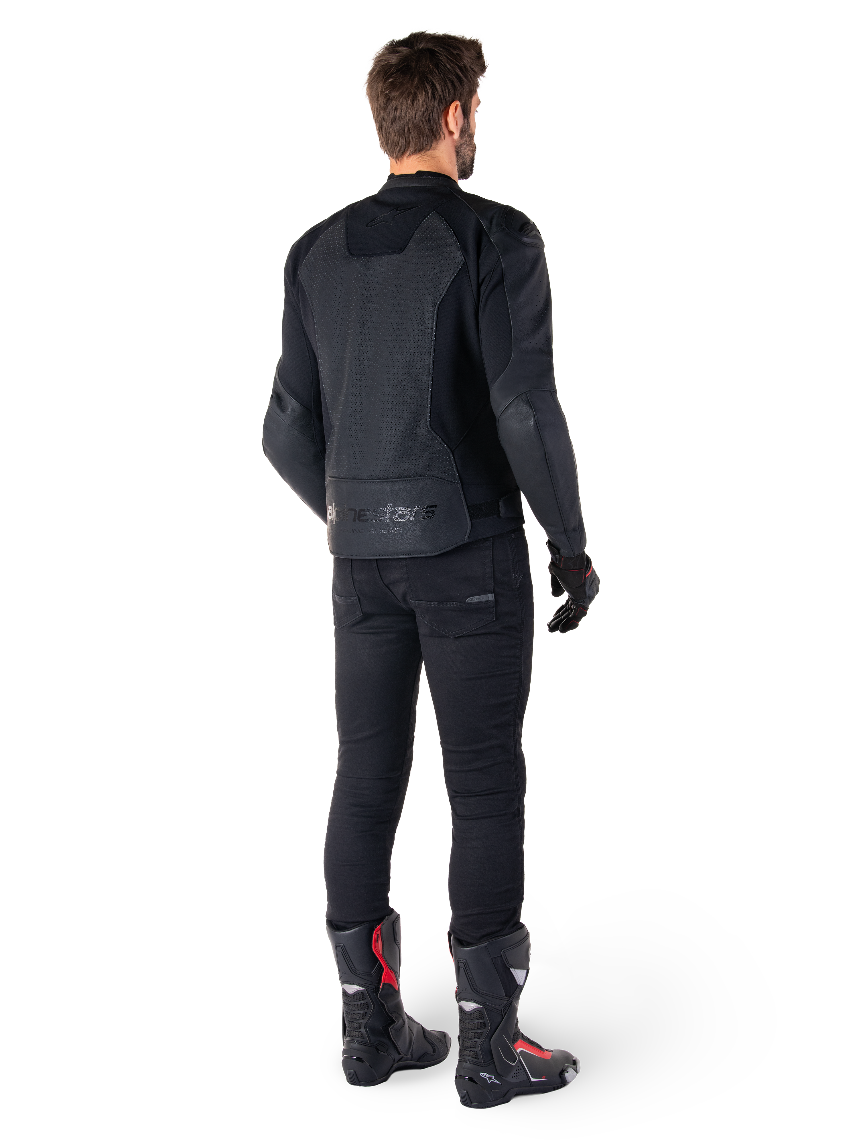 Alpinestars Faster V3 Airflow Leather Jacket, Nero, vista posteriore di un uomo che indossa una giacca sportiva in pelle con pannelli posteriori traforati e marchio Alpinestars, abbinata a pantaloni da moto neri e stivali neri e rossi.