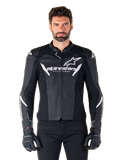 Alpinestars Faster V3 Airflow Leather Jacket, giacca da moto nera con dettagli bianchi, pannelli in pelle traforata per la ventilazione, logo Alpinestars sul petto, indossata con guanti neri, costruzione in pelle di derivazione sportiva