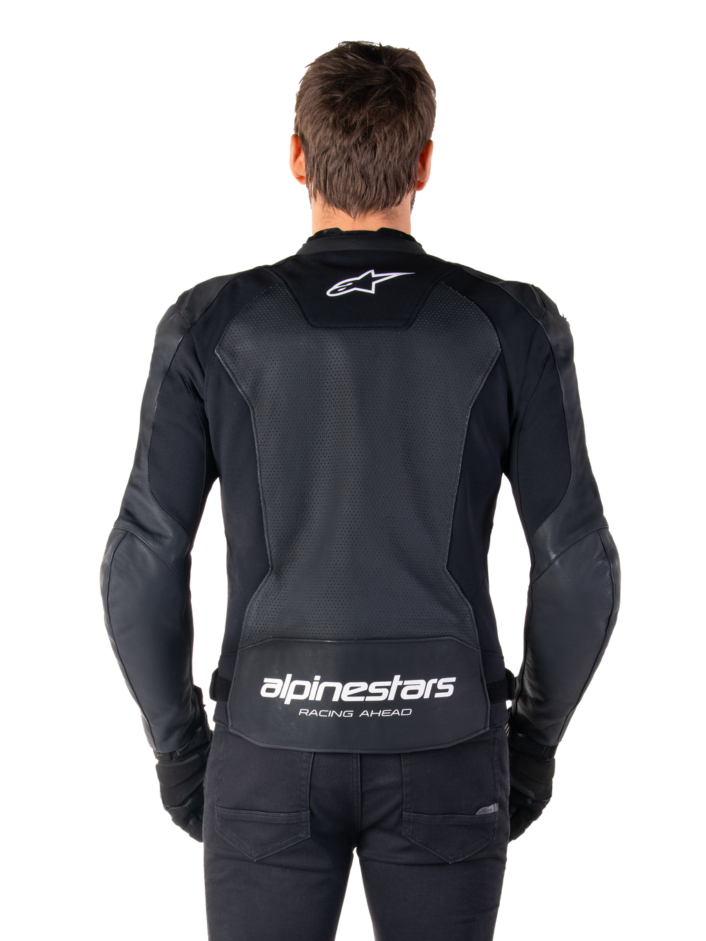 Giacca in pelle Alpinestars Faster V3 Airflow, nero e bianco, vista posteriore di un pilota che mostra il pannello posteriore in pelle traforata per la ventilazione, logo Alpinestars bianco sulla parte superiore della schiena e marchio 'RACING AHEAD' sulla parte inferiore della schiena, abbigliamento da moto sportivo.