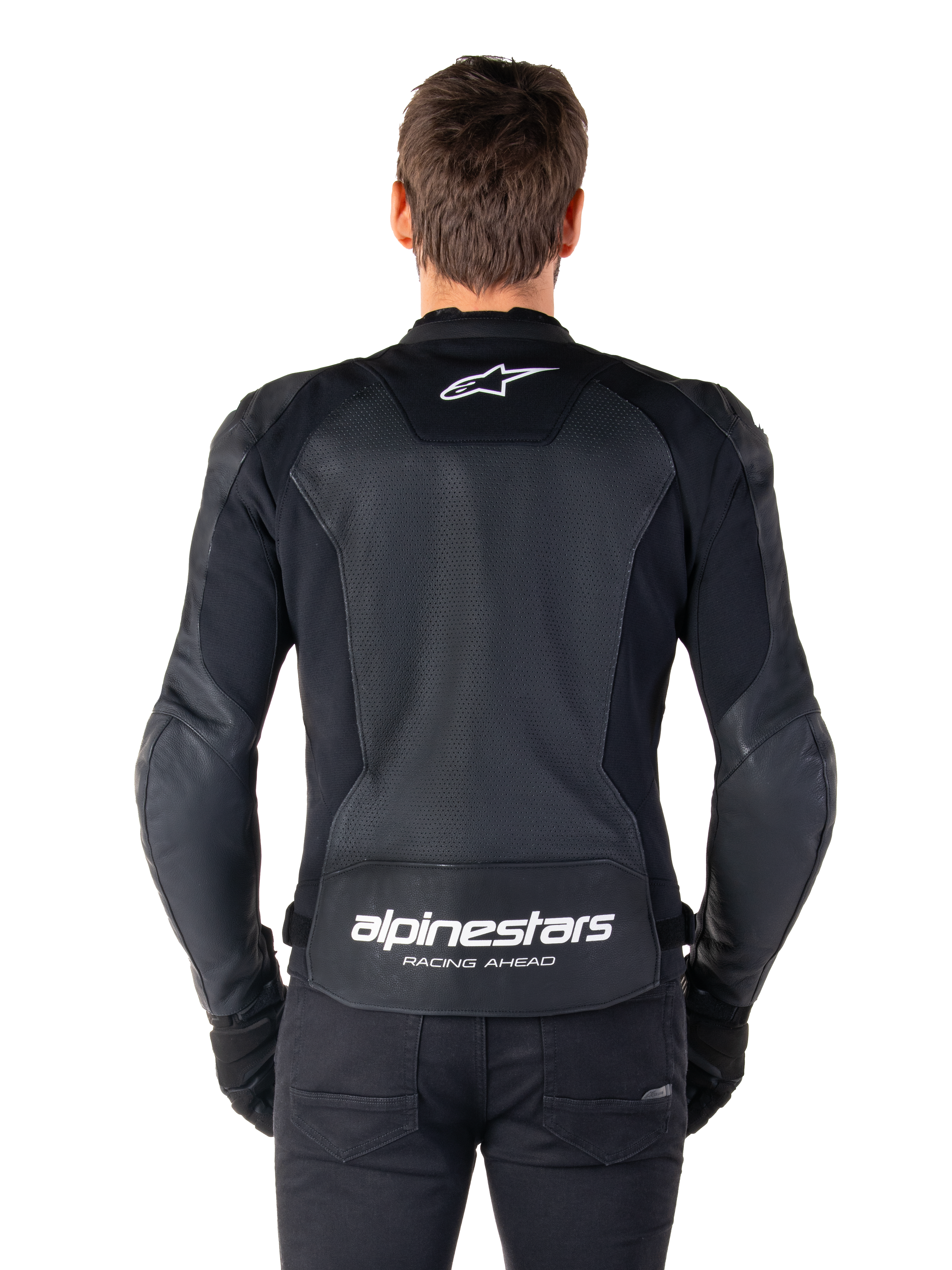 Giacca in pelle Alpinestars Faster V3 Airflow, nero e bianco, vista posteriore di un pilota che mostra il pannello posteriore in pelle traforata per la ventilazione, logo Alpinestars bianco sulla parte superiore della schiena e marchio 'RACING AHEAD' sulla parte inferiore della schiena, abbigliamento da moto sportivo.