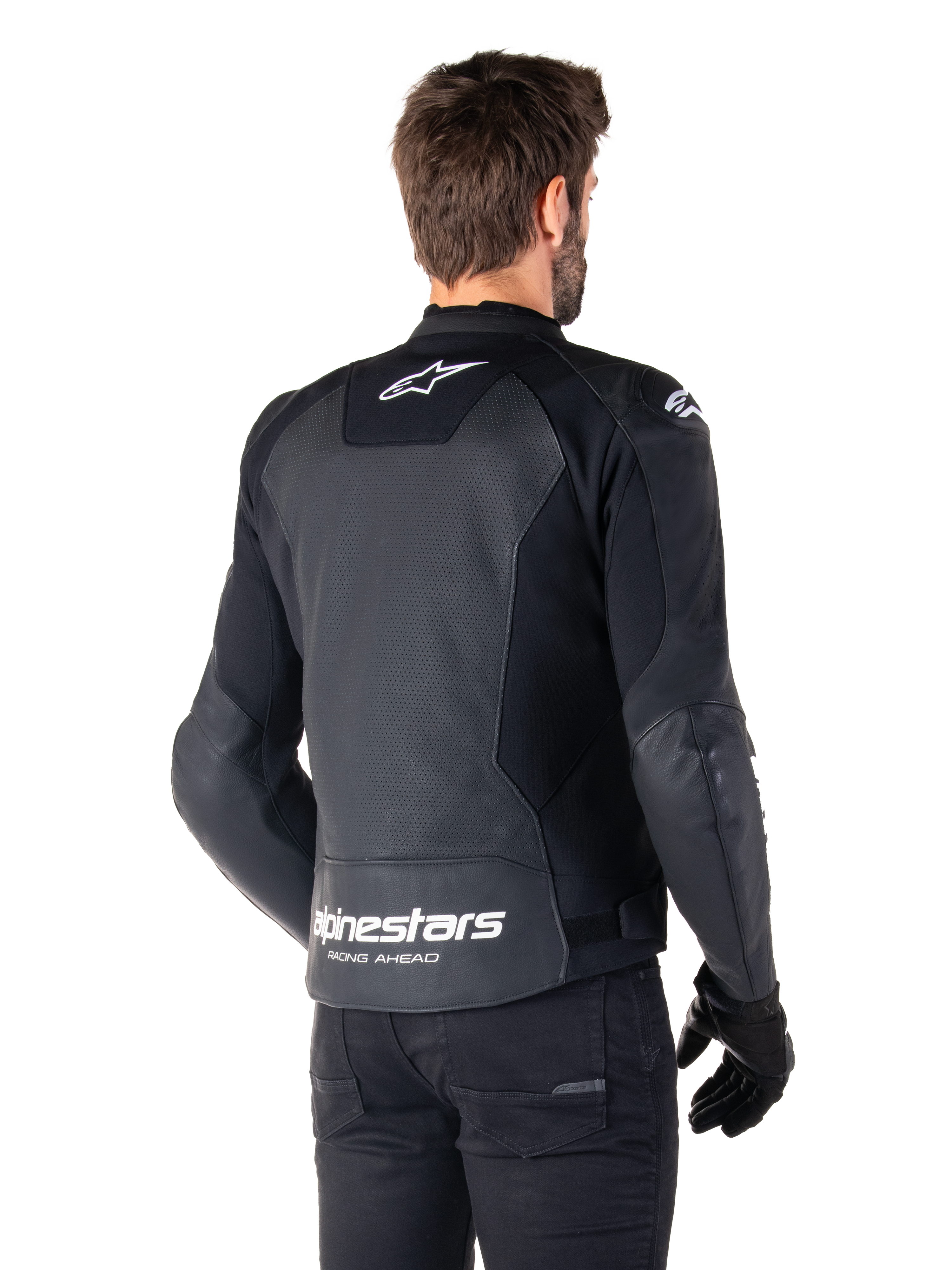 Giacca in pelle Alpinestars Faster V3 Airflow, nero e bianco, vista posteriore su un modello, con schiena in pelle traforata per la ventilazione, loghi Astars bianchi e scritta 'Racing Ahead', design sportivo con pannelli elasticizzati per il motociclismo.