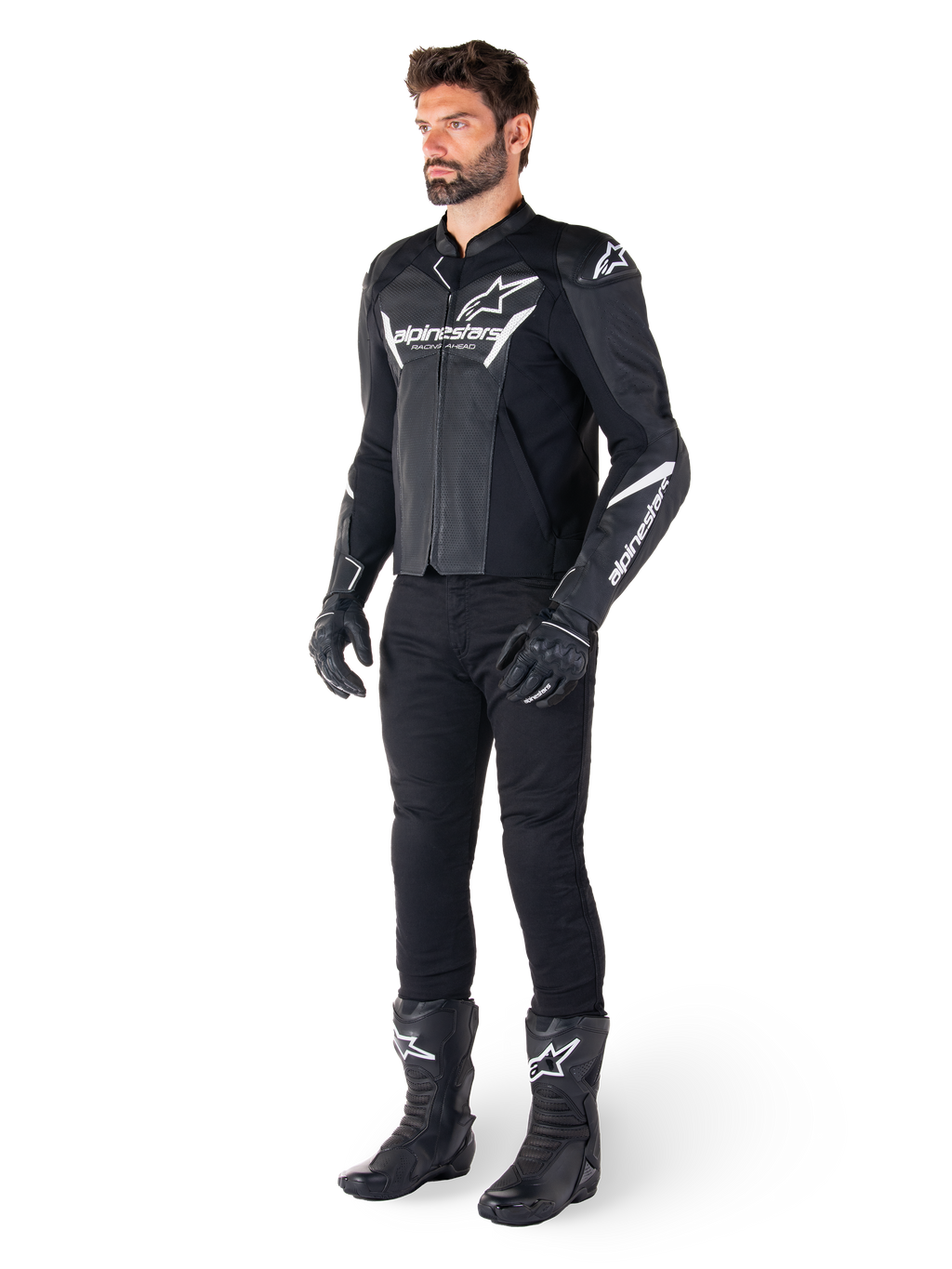 Giacca in pelle Alpinestars Faster V3 Airflow, nero e bianco, con pelle traforata e loghi Alpinestars bianchi, indossata con pantaloni da moto neri, guanti e stivali, equipaggiamento da moto sportivo
