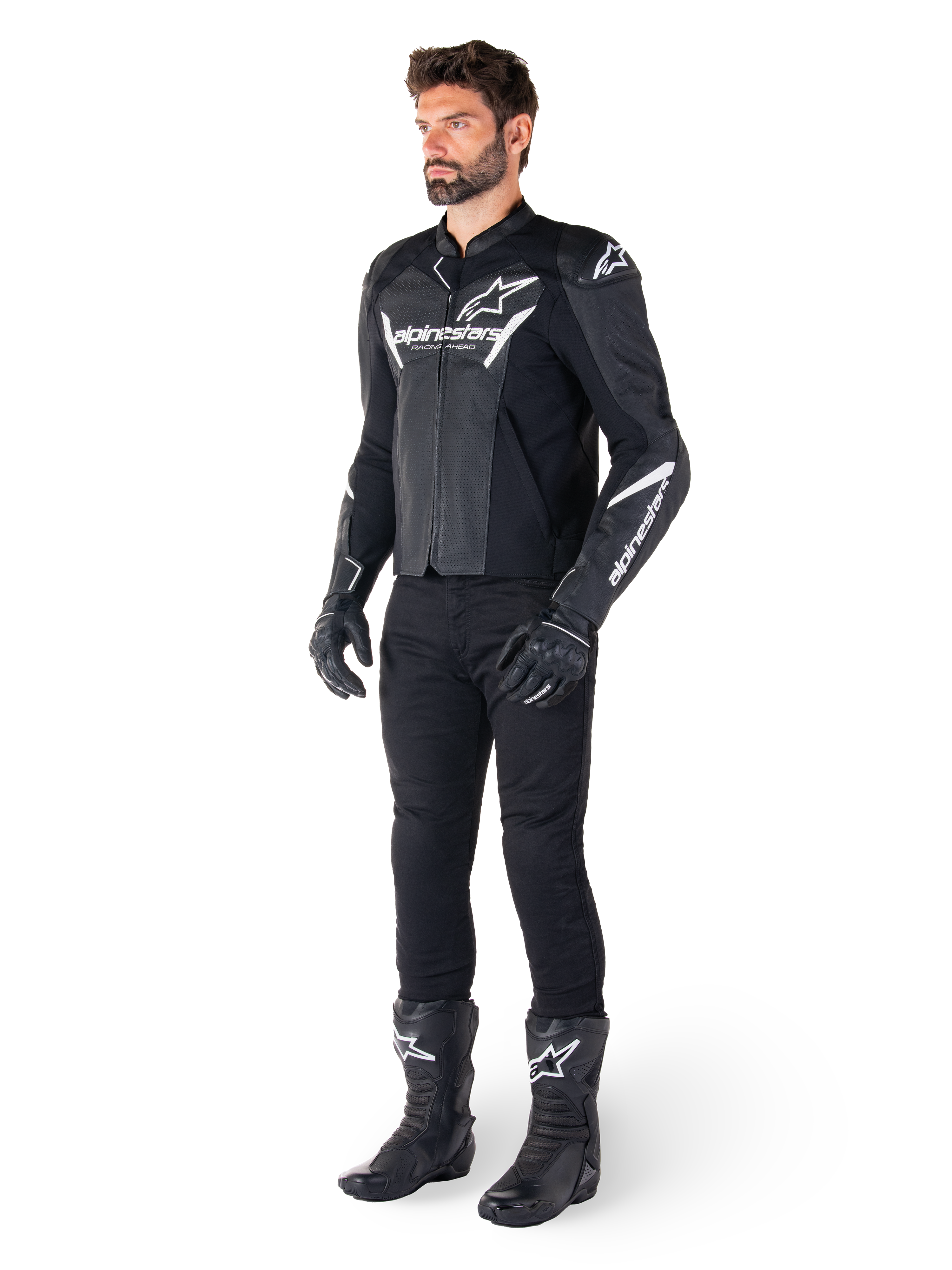 Giacca in pelle Alpinestars Faster V3 Airflow, nero e bianco, con pelle traforata e loghi Alpinestars bianchi, indossata con pantaloni da moto neri, guanti e stivali, equipaggiamento da moto sportivo