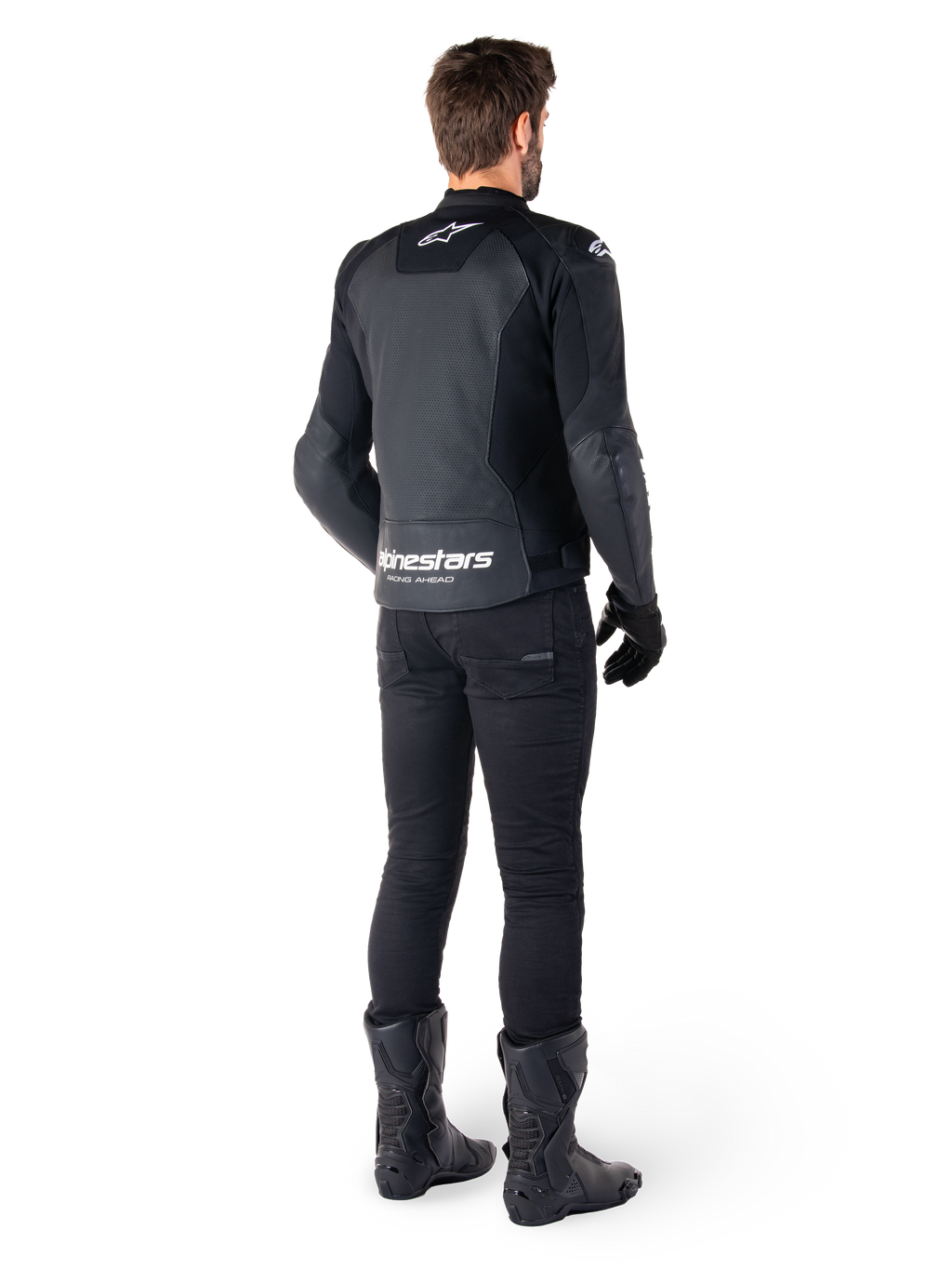 Giacca in pelle Alpinestars Faster V3 Airflow, nera e bianca, vista posteriore che mostra i pannelli in pelle traforata e il marchio Alpinestars sulla parte bassa della schiena, indossata da un motociclista con pantaloni, guanti e stivali neri.