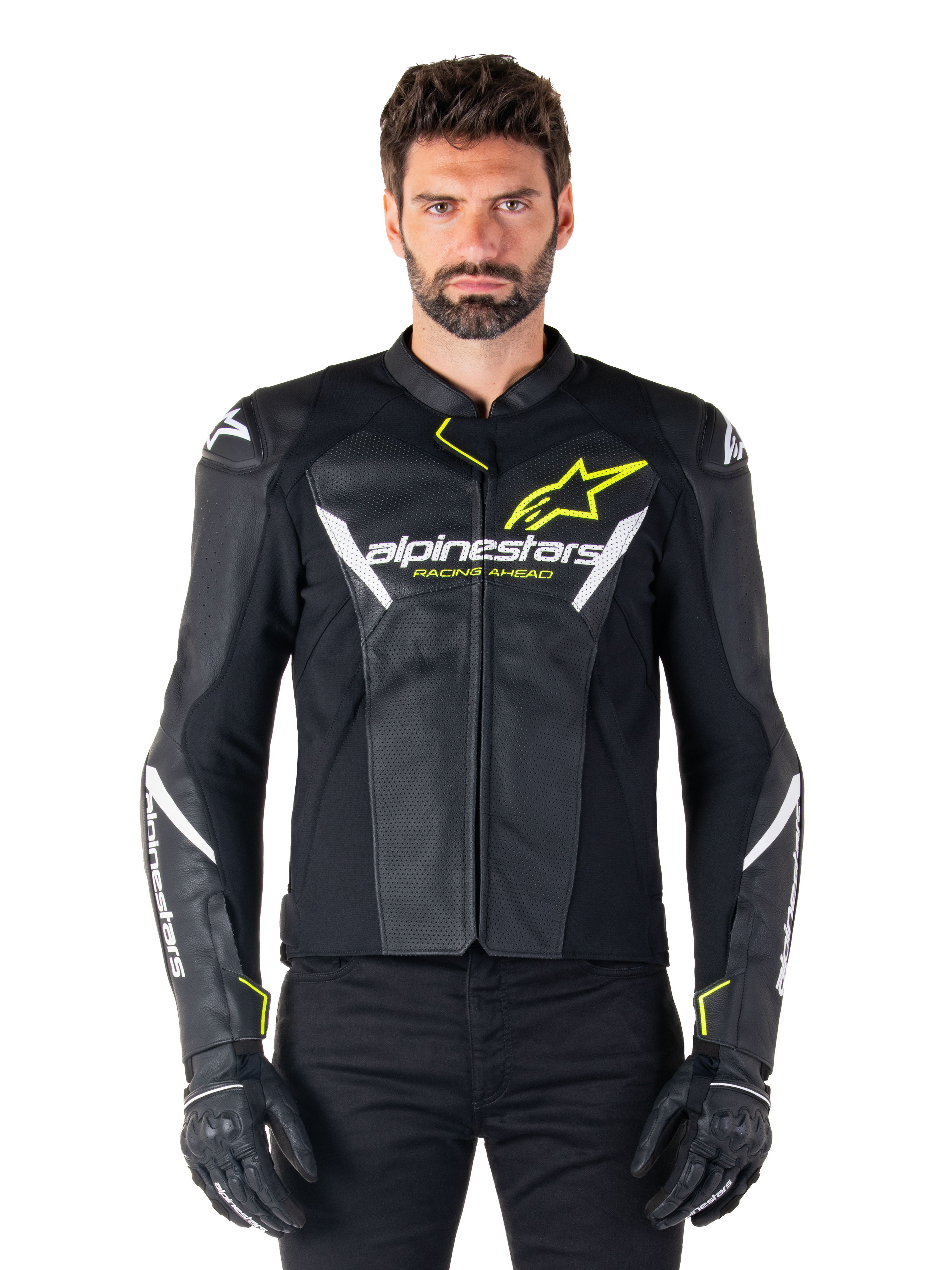 Giacca in pelle Alpinestars Faster V3 Airflow, nero, bianco e giallo fluo, indossata da un modello maschile con guanti neri coordinati, con pannelli in pelle traforata per la ventilazione ed evidente marchio Alpinestars sul petto, abbigliamento sportivo per motociclismo