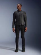 Modello che indossa la giacca in pelle Alpinestars Blacktrack, pelle bovina premium nera, design da motociclista moderno e minimalista con vestibilità su misura, abbinata a pantaloni da moto e stivali neri, stile urbano contemporaneo