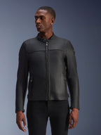 Giacca in pelle Alpinestars Blacktrack, nera, giacca da moto, indossata da un modello, dotata di zip frontale metallica, colletto alto e tasche con zip, costruzione in pelle premium per un look moderno e minimalista