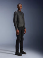 Modello che indossa la giacca in pelle Alpinestars Blacktrack, nero su nero, stile biker moderno in pelle premium con dettagli delle zip metalliche, abbinata a pantaloni e stivali neri per un look urbano contemporaneo