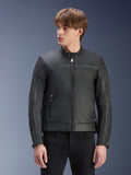 Giacca in pelle Alpinestars Dyno, nero, giacca da moto in pregiata pelle bovina, indossata da un modello con pantaloni neri, design d'ispirazione heritage con cerniera centrale e colletto alla coreana a profilo basso, abbigliamento da moto urban contemporary.