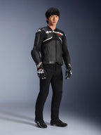 Giacca in pelle Alpinestars Atem V5, giacca da moto racing, nero e bianco, indossata con pantaloni neri e guanti coordinati, con logo Alpinestars bianco sul petto e protezioni sulle spalle
