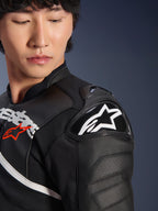 Primo piano della giacca in pelle Alpinestars Atem V5 in nero e bianco, con protezione per la spalla DFS RR con logo a stella bianco, costruzione in pelle traforata e grafiche sul petto ispirate alle corse.