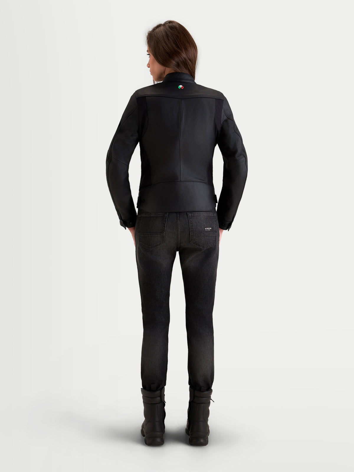 Alpinestars Stella Maver X Giacca di pelle, giacca da moto urbana da donna in pelle, nera, vista posteriore su una modella che mostra la pregiata struttura in pelle bovina e il taglio sartoriale da strada