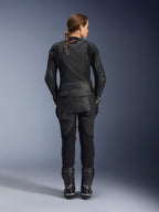 Alpinestars Giacca in pelle Stella GP Plus V4 da donna, Nero Nero, vista posteriore a figura intera di una motociclista con pantaloni in pelle e stivali coordinati, design minimalista con un piccolo logo rosso sul collo, silhouette sportiva sagomata per donna