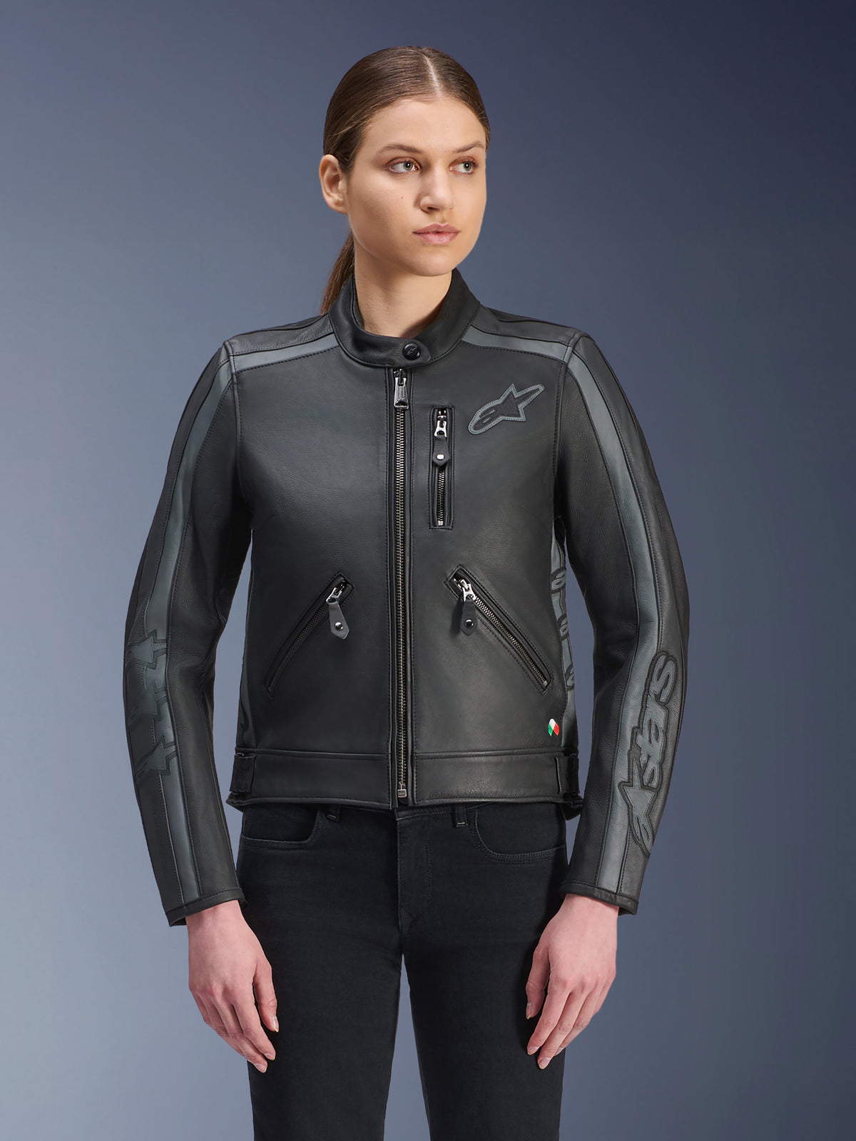 Giacca in pelle Alpinestars Stella Dyno, giacca da moto da donna, nero e grigio fumo, costruzione in pelle bovina premium con dettagli a strisce grigie su spalle e maniche, tasche anteriori con zip e logo ricamato sul petto, abbigliamento da moto urbano elegante