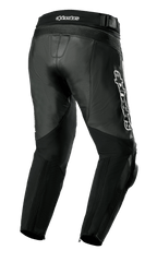 Pantaloni in pelle Alpinestars Missile V3, pantaloni da moto, nero, vista posteriore di tre quarti con costruzione in pelle premium, pannelli elastici a fisarmonica sopra le ginocchia e sulla vita, vita posteriore alta e logo Alpinestars bianco prominente sul lato.