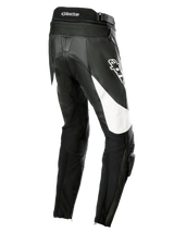 Alpinestars Stella Missile V3 Leather Pants, pantaloni da moto racing da donna, nero con accenti bianchi, vista posteriore a tre quarti con pannelli elasticizzati a fisarmonica sulla parte bassa della schiena, logo Alpinestars sulla coscia e slider ginocchia integrati per la guida sportiva