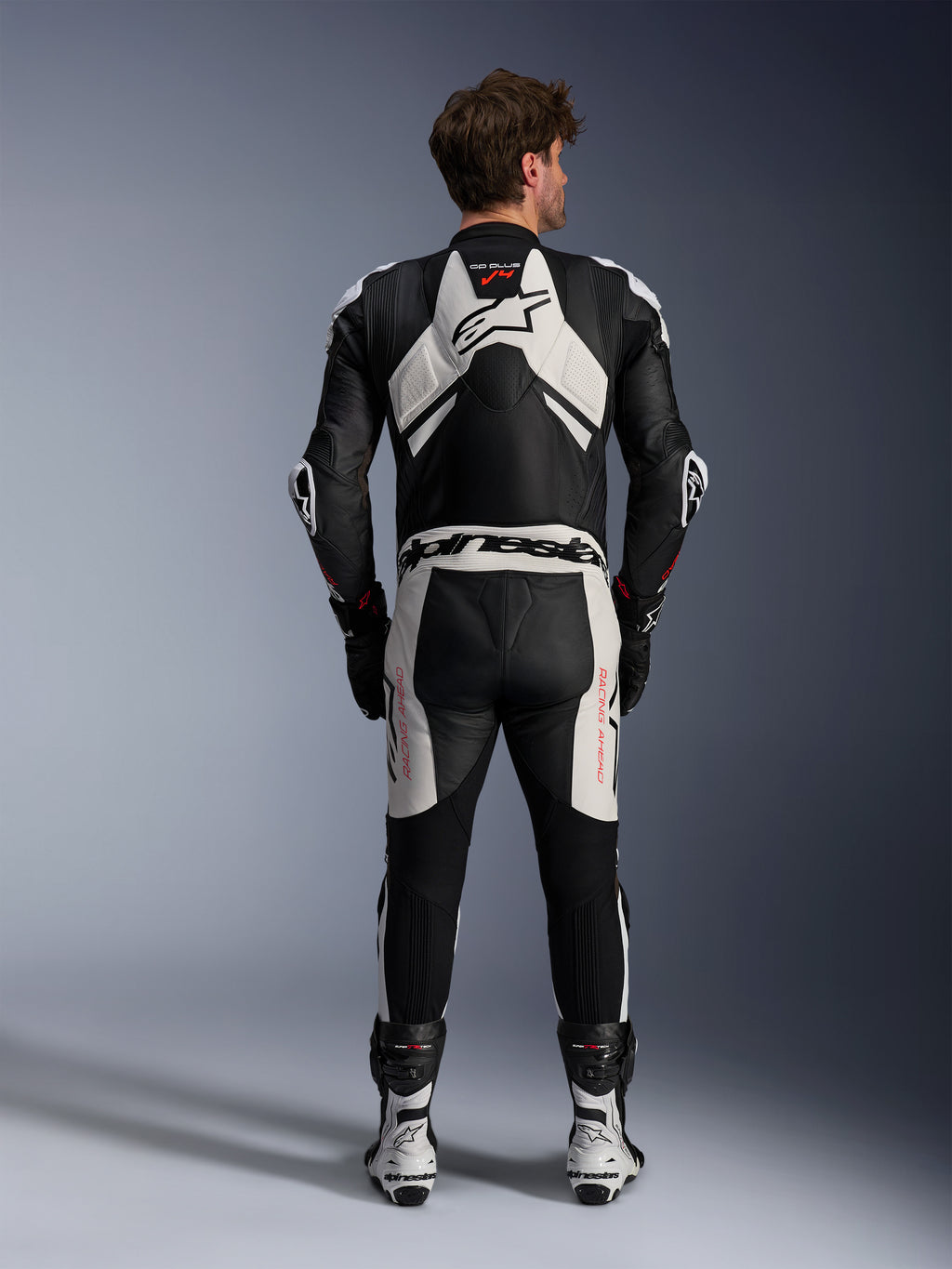 Alpinestars Tuta in pelle GP Plus V4 Sprint 1 Pezzo, tuta da corsa uomo, nero e bianco con rosso fluo, vista posteriore con gobba aerodinamica.