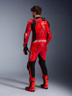Alpinestars Tuta in pelle GP Plus V4 Sprint, tuta da corsa da uomo, rosso fluo e rosso mid con accenti bianchi, Tech-Air ready, gobba aerodinamica, vista posteriore su modello con stivali e guanti racing.