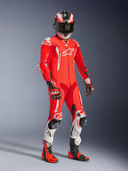 Pilota di moto con tuta in pelle intera Alpinestars GP Tech V5, Rosso Fluo e Rosso Brillante con dettagli bianchi, completa di casco, guanti e stivali da corsa abbinati, abbigliamento professionale da pista con pelle traforata e slider protettivi