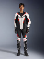 Alpinestars GP Force V2 Leather Suit - 1Piece, Bianco Nero Rosso Fluo, tuta da moto intera in pelle, vista frontale su modello, con pannelli traforati e accenti rossi, logo Alpinestars prominente sul petto, abbinata a stivali e guanti da corsa professionali