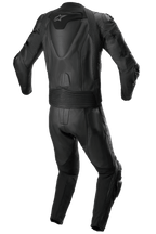 Tuta in pelle Alpinestars Missile V2 2 pezzi, tuta da corsa in pelle, completamente nera, vista posteriore che mostra la gobba aerodinamica con logo a stella bianco, pannelli a fisarmonica elasticizzati in vita e sulle spalle e dettagli in pelle traforata per la guida sportiva in moto