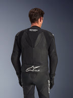 Tuta in pelle Alpinestars GP Force V2 2 Pezzi, nera, vista posteriore del pilota, con pannelli in pelle traforata, gobba aerodinamica con marchio GP Force e logo Alpinestars bianco con scritta Tech-Air Ready sulla parte bassa della schiena
