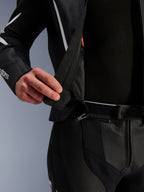 Tuta in pelle Alpinestars GP Force V2 - 2 pezzi, dettaglio ravvicinato della cerniera di connessione a 360 gradi in vita, pelle traforata nera con accenti bianchi, che mostra il sistema di fissaggio sicuro tra giacca e pantaloni.
