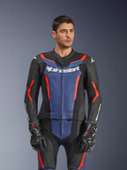 Modello che indossa la tuta in pelle Alpinestars GP Force V2 2 pezzi, nero blu rosso fluo, con audace pannello blu sul petto e accenti rossi, abbinata a guanti GP Pro, abbigliamento professionale da gara in pelle con texture traforata